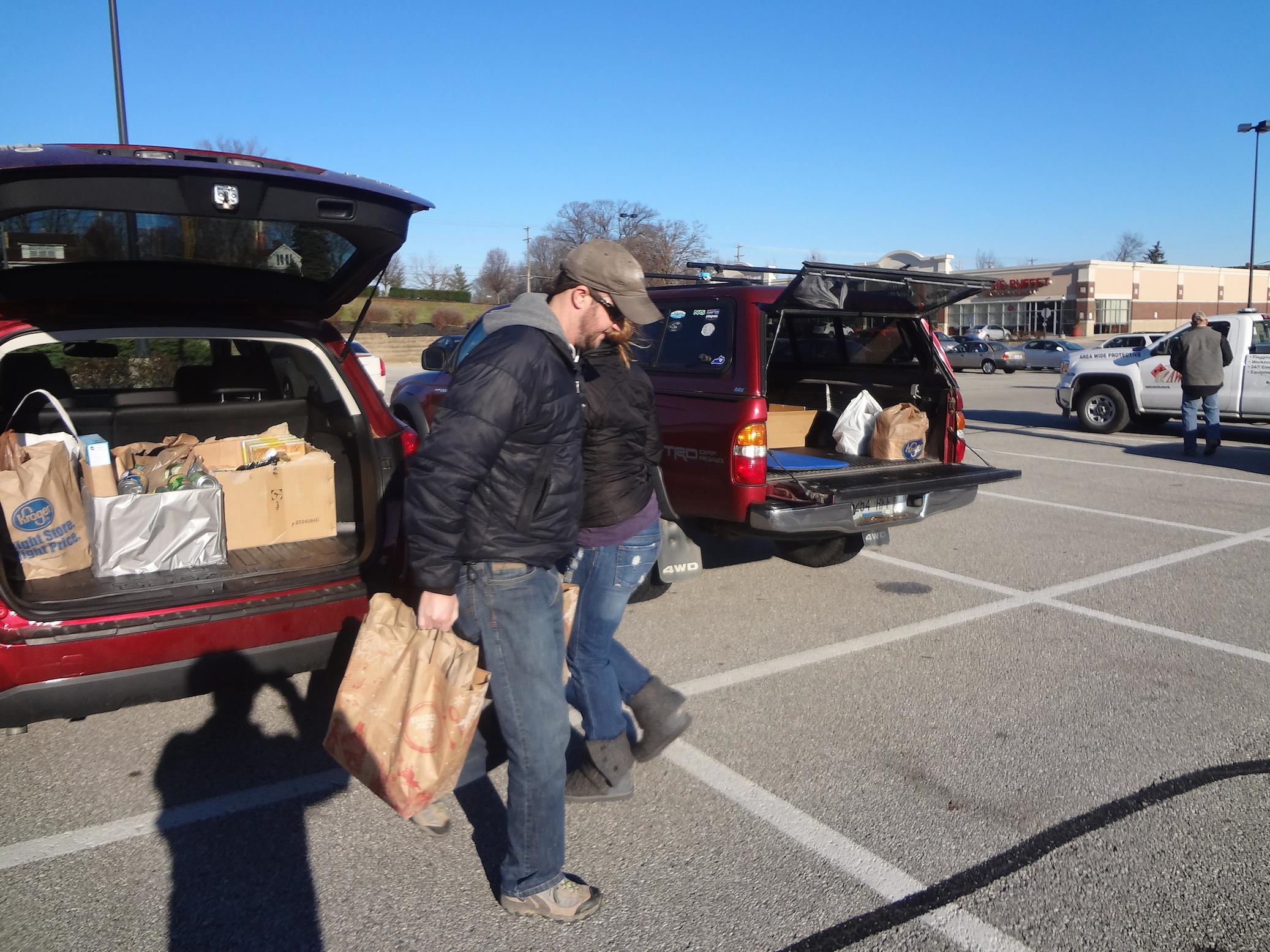 photo of volunteers unloading donated goods from a car